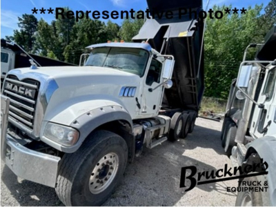 Mack GR64F dump truck in-service showing front grille, bumper, and wheel, with a dump bed visible in background.