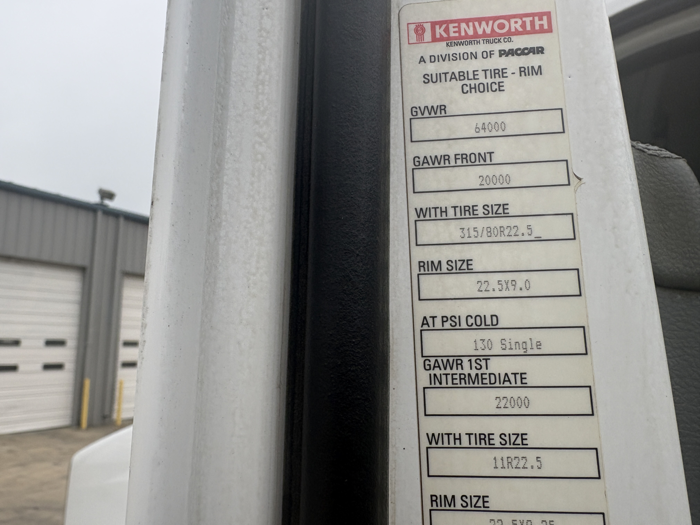 Kenworth label on door jamb with tire and load specifications: GVWR 40000, GAWR front 20000, with tire size 315/80R22.5, rim size 22.5x9.0, AT PSI cold 130, GAWR 1st intermediate 22000, with tire size 11R22.5, rim size 22.5x9.0.