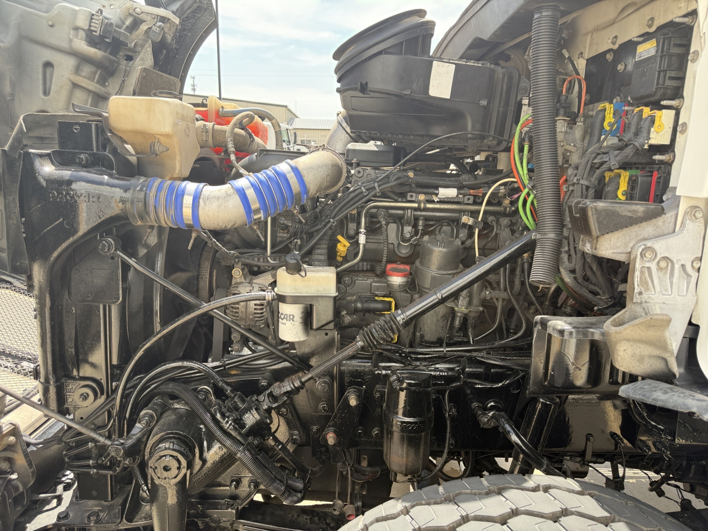 Kenworth T880 engine bay showing air intake and engine components with hoses and wiring visible
