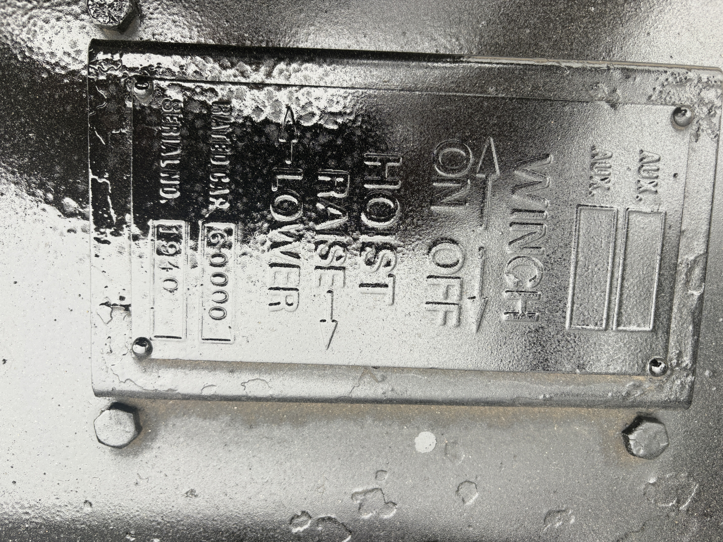 Engine bay label showing throttle and transmission specs with 'WING' and 'HOT STOP' text, alert indicators, stamped metal plate with vertical text.