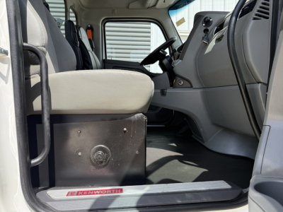 Kenworth T880 cab interior showing driver seat, dashboard, and entry step with Kenworth branding; VIN and stock info visible in listing context.
