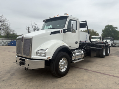 Kenworth T880 roll-off truck side view showing cab, front grille, fuel tanks, dual rear axles, and winch bed.