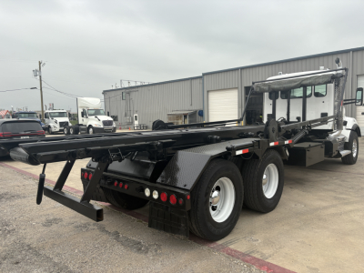Kenworth T880 roll-off truck rear and side view showing flatbed and rear bumper with lights.