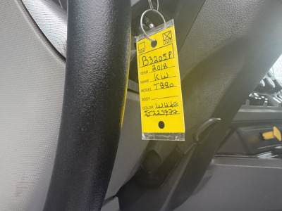 Tag hanging in Kenworth truck cabin with handwritten details: B3205P, 2018, Make KW, Model T880, Year 2018, VIN 1NKZLP0X2JJ223977, Color ???