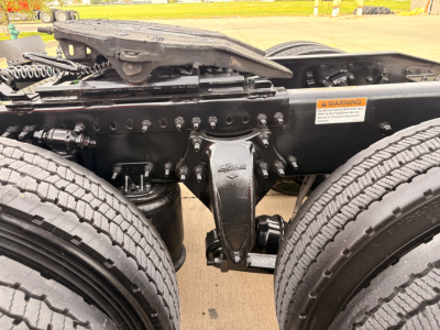 Freightliner PT126064S truck chassis showing drive axle and suspension components with dual tires and warning sticker.