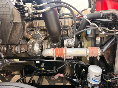 Engine bay of Freightliner PT126064S T showing engine components, hoses, radiator, and filter canister.