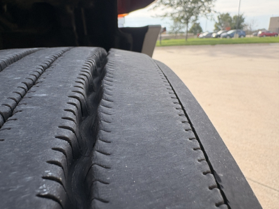 Truck wheel and tire tread close-up in the engine bay area showing truck wheel and fender.