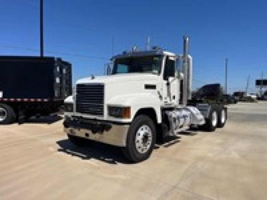 White 2019 Mack PI64T daycab truck in a lot, front-left view showing cab, grille, and dual rear axles.