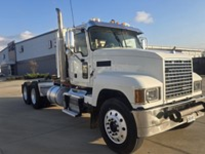 Truck side view showing 2019 Mack PI64T conventional daycab with large chrome grille and dual rear axles.