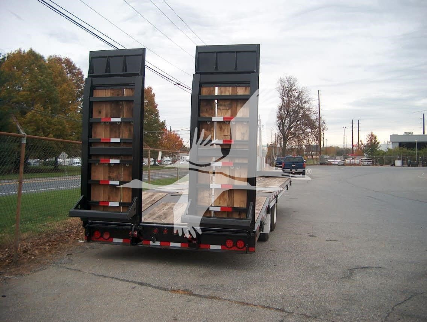Trailer with dual ramps; 20Xpt equipment trailer from rear view showing loading ramps and wooden deck.