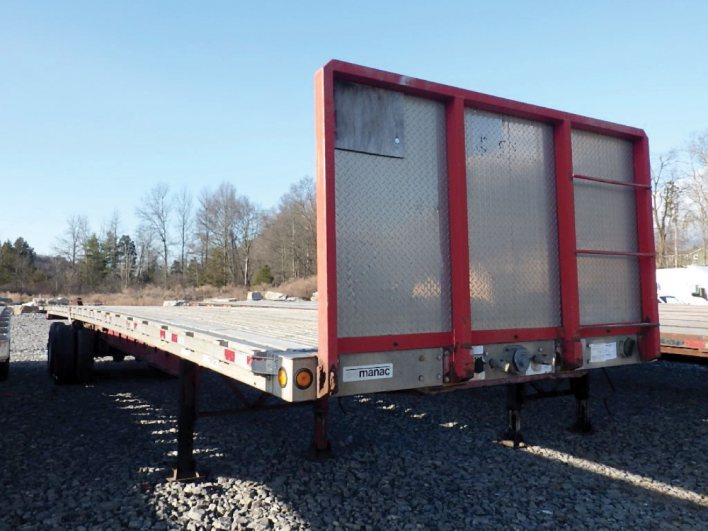 Manac trailer showing aluminum and steel composite flatbed with red uprights and rear uprights, flat deck, used condition.