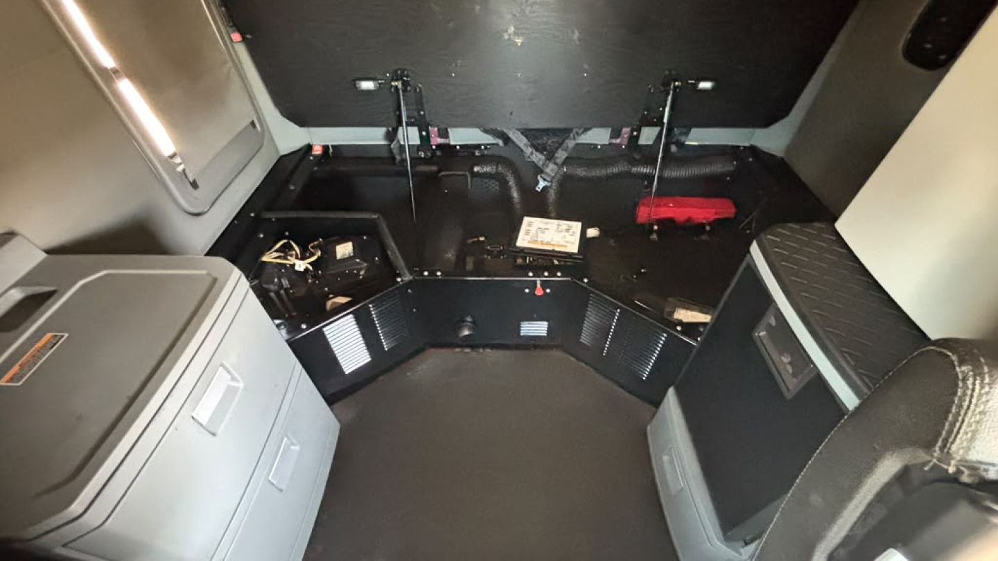 Kenworth T680 cab interior with storage compartments and control panels visible