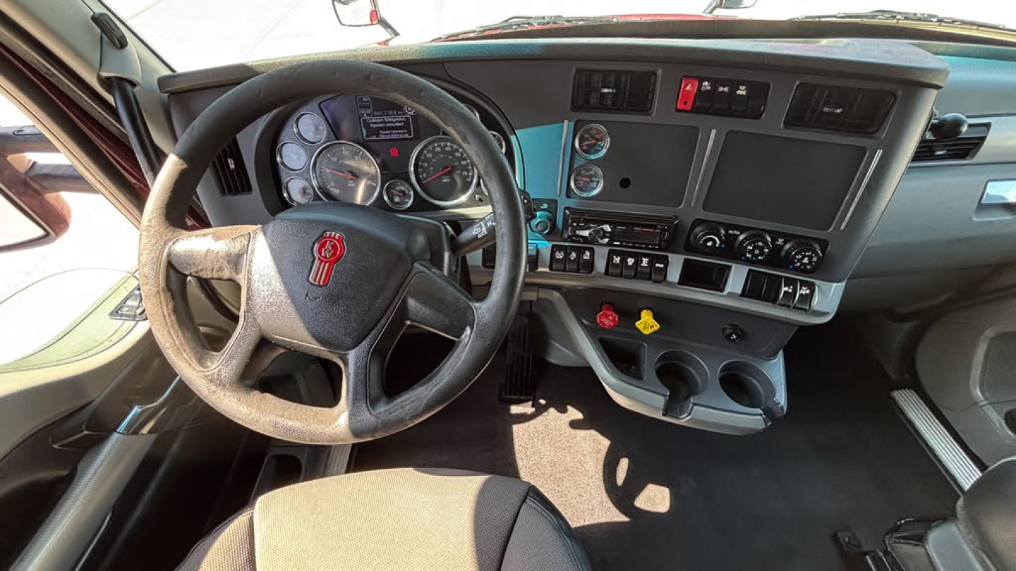 Kenworth T680 dash and steering wheel interior with gauge cluster and center console; visible switches and controls.