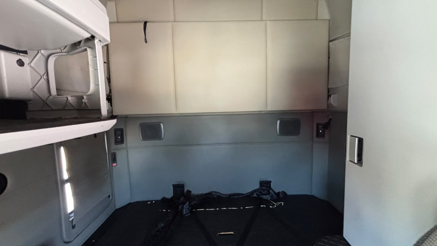 Kenworth T680 sleeper cab interior cargo area showing side wall panels and storage compartments.