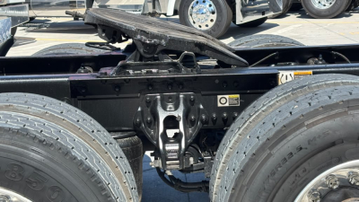 Kenworth T680 chassis rear view showing dual rear axles and fifth wheel mounting area with visible suspension parts and frame crossmember.