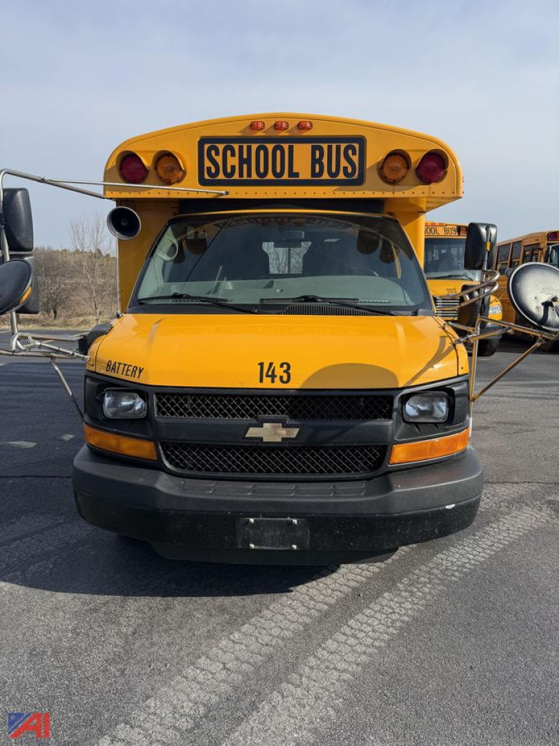 Front view of a yellow 2014 Chevrolet Express G3500 mini school bus with 'SCHOOL BUS' sign, black grille, and headlights.