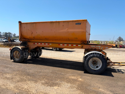 Peterbilt 378 dump truck trailer with orange hopper and dual rear wheels viewed from side in a truck yard.