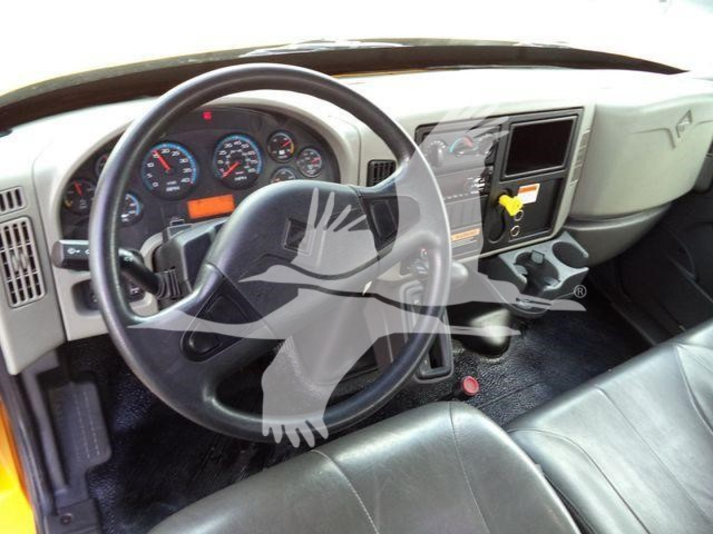 Truck cab interior showing steering wheel and dashboard with gauges for a 2019 International Durastar 4300, left-hand drive, gray dash and black steering wheel.