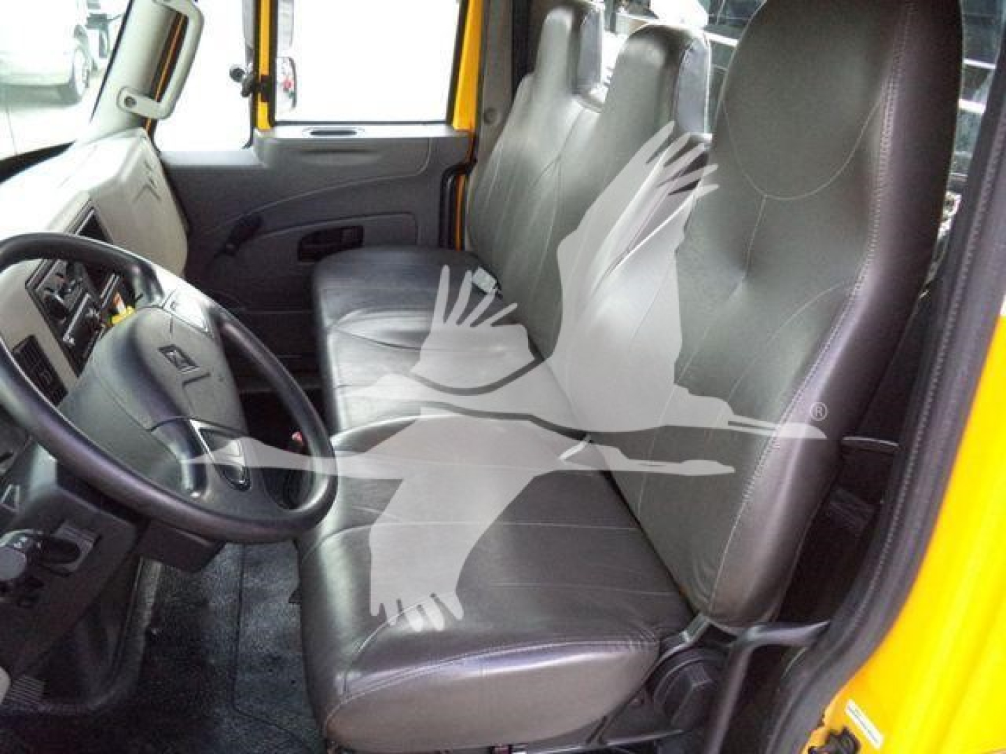 Cab interior of a 2019 International Durastar 4300 with grey vinyl seats, steering wheel, and front door; no visible text on components.