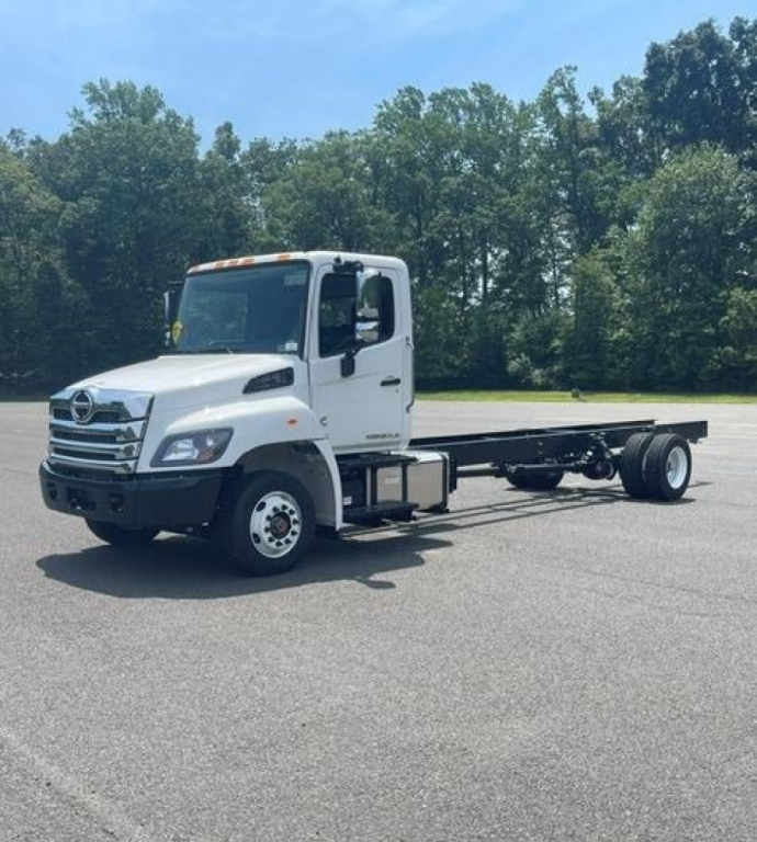 Box van truck chassis showing white cab and undecked frame with dual rear wheels