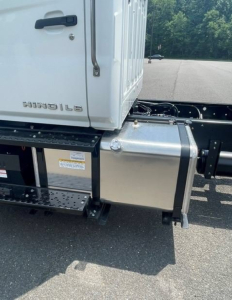 Hino L6 cab and chassis area showing side step, fuel/anti-exposure box, and truck lettering HINO L6 on cab side.