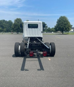 Rear view of a new Hino L6 box van truck chassis showing dual rear axles and tail lamps.