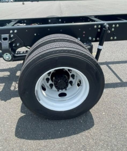 Hino L6 truck chassis showing wheel and suspension with black undercarriage and white rim.
