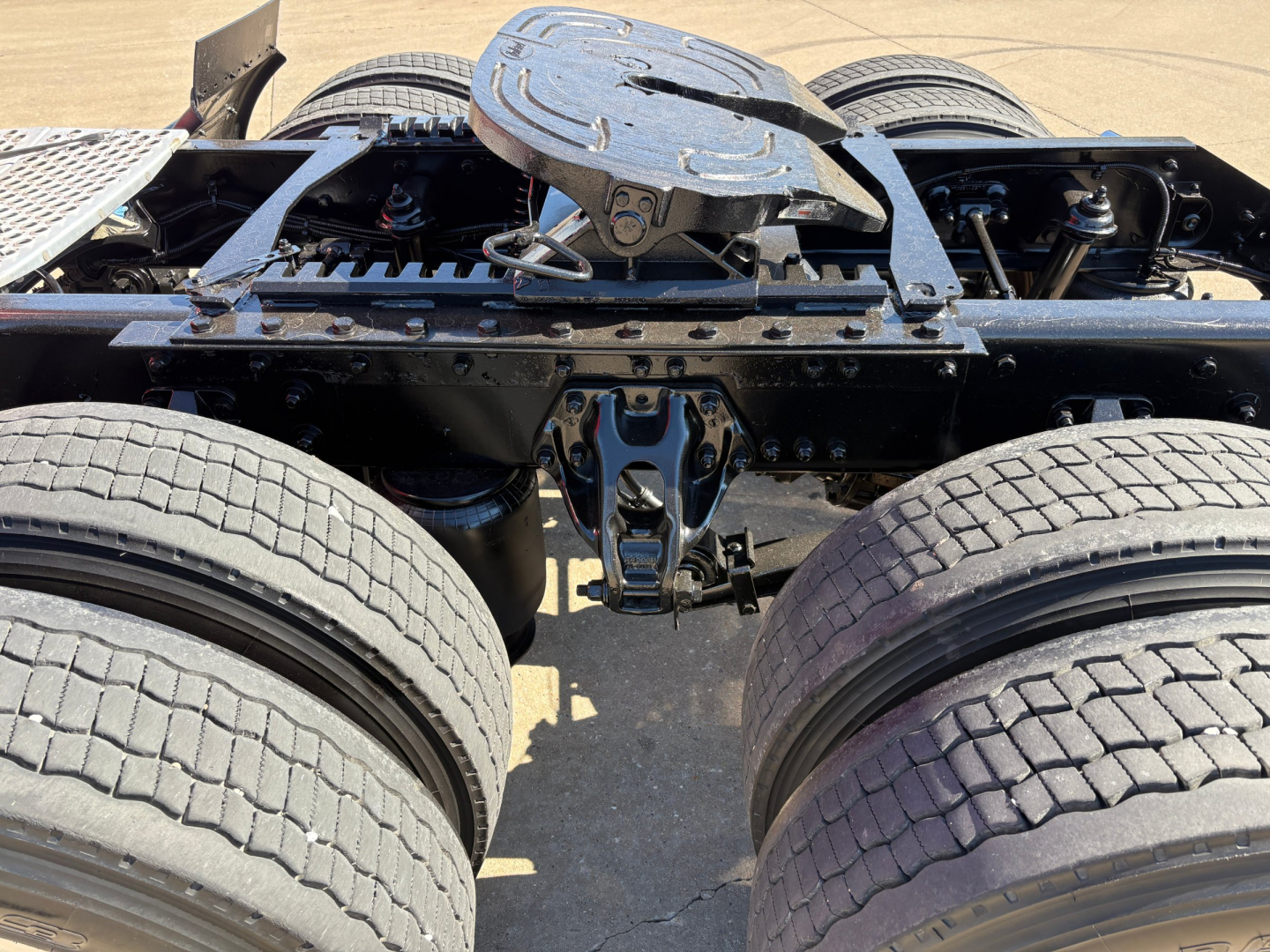 Kenworth truck chassis and fifth wheel area showing rear configuration and dual rear axles from a top view.