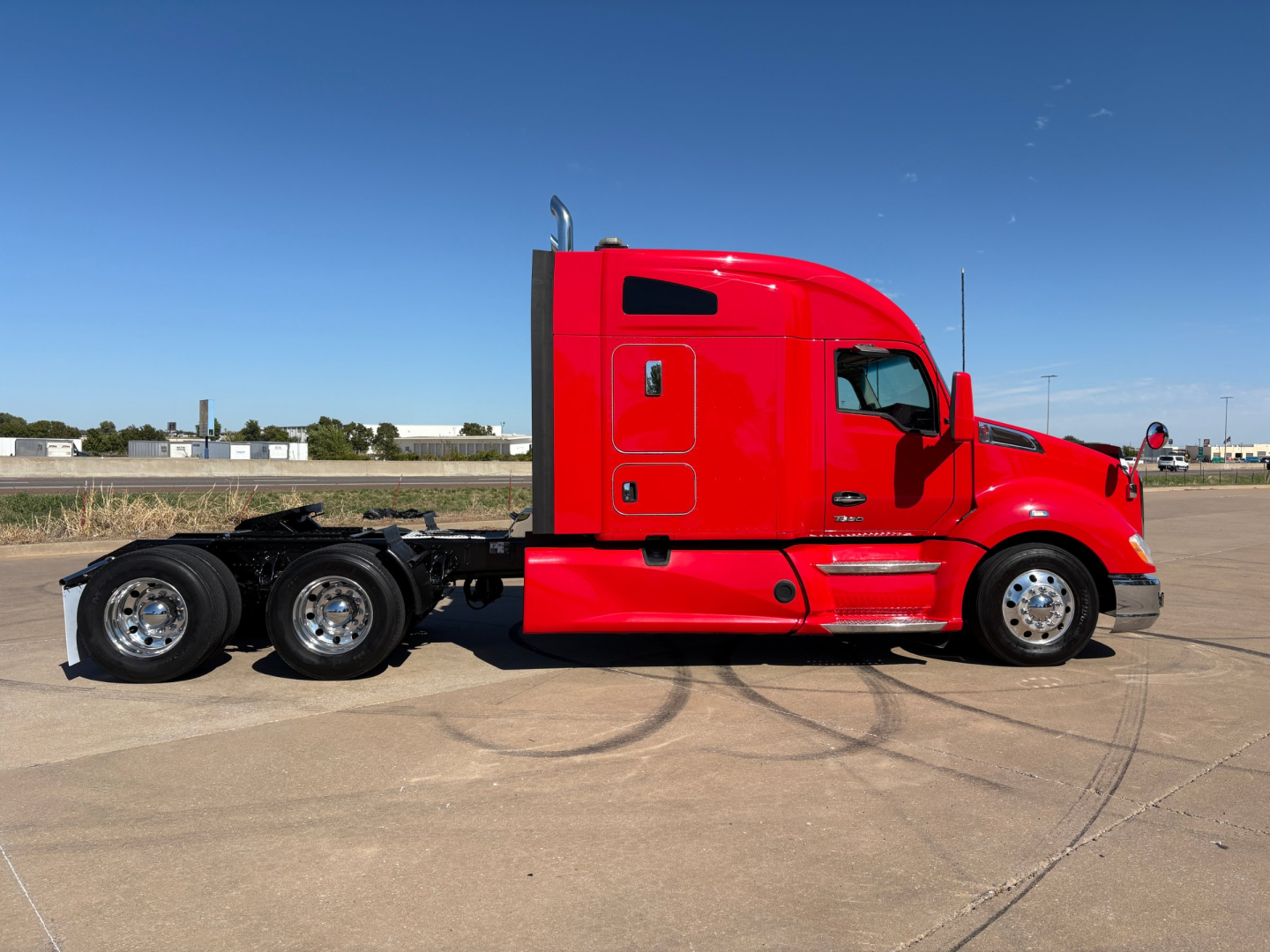 Kenworth T680 tractor in red side profile view showing cab and rear axles, VIN 1XKYDP9X2NJ100512 visible on listing.