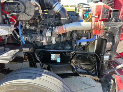 Kenworth T680 engine bay showing radiator, hoses, and exposed engine components in a pickup truck style layout.