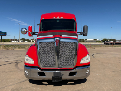 Kenworth T680 truck front view showing bold grille and headlights with red cab and chrome bumper