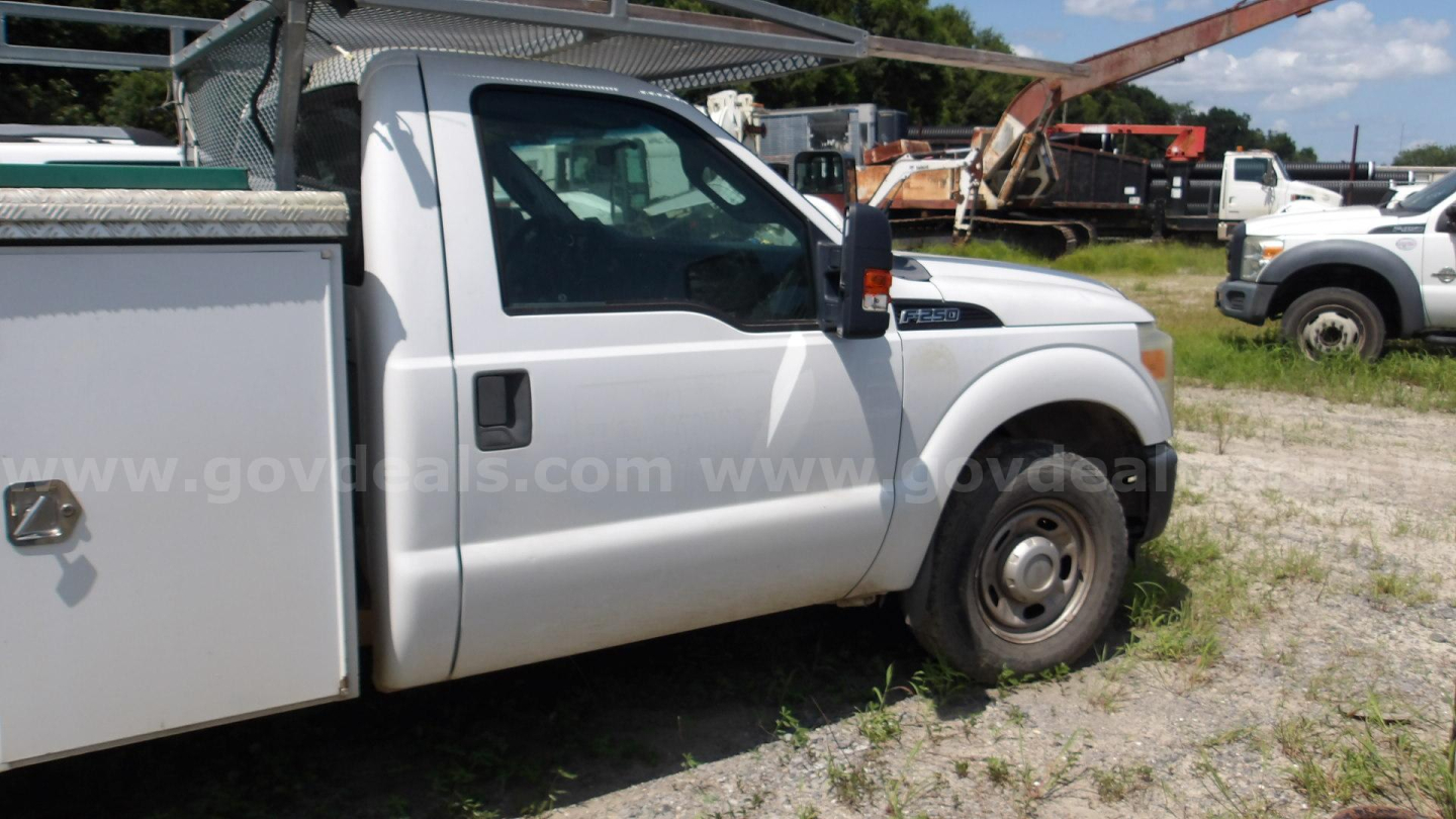 Ford F-250 service truck side view showing front wheel and utility cargo box