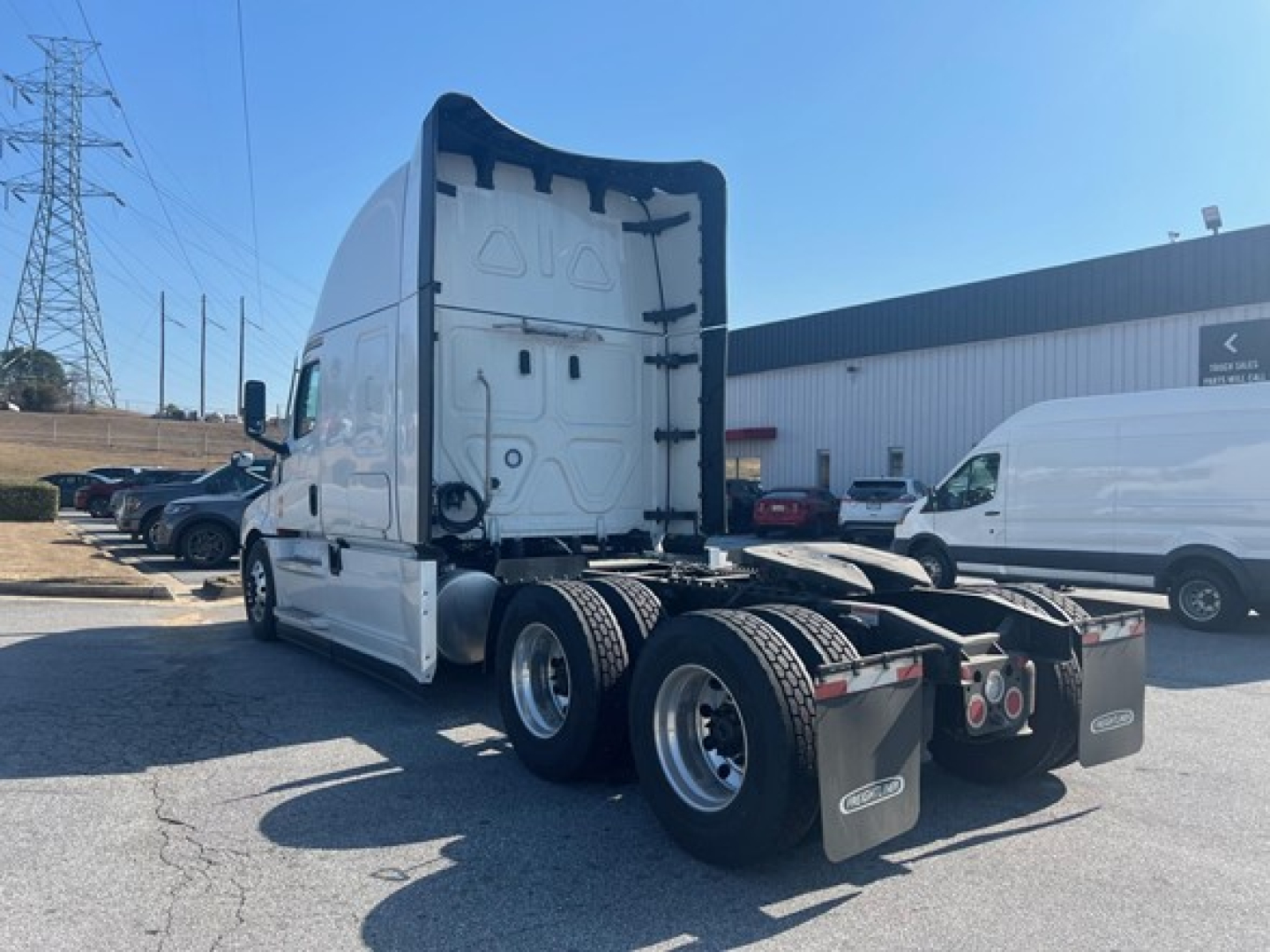 Freightliner Cascadia 126 tractor with sleeper configuration, side view showing rear dual axles and fifth wheel area, white exterior, no trailer attached.