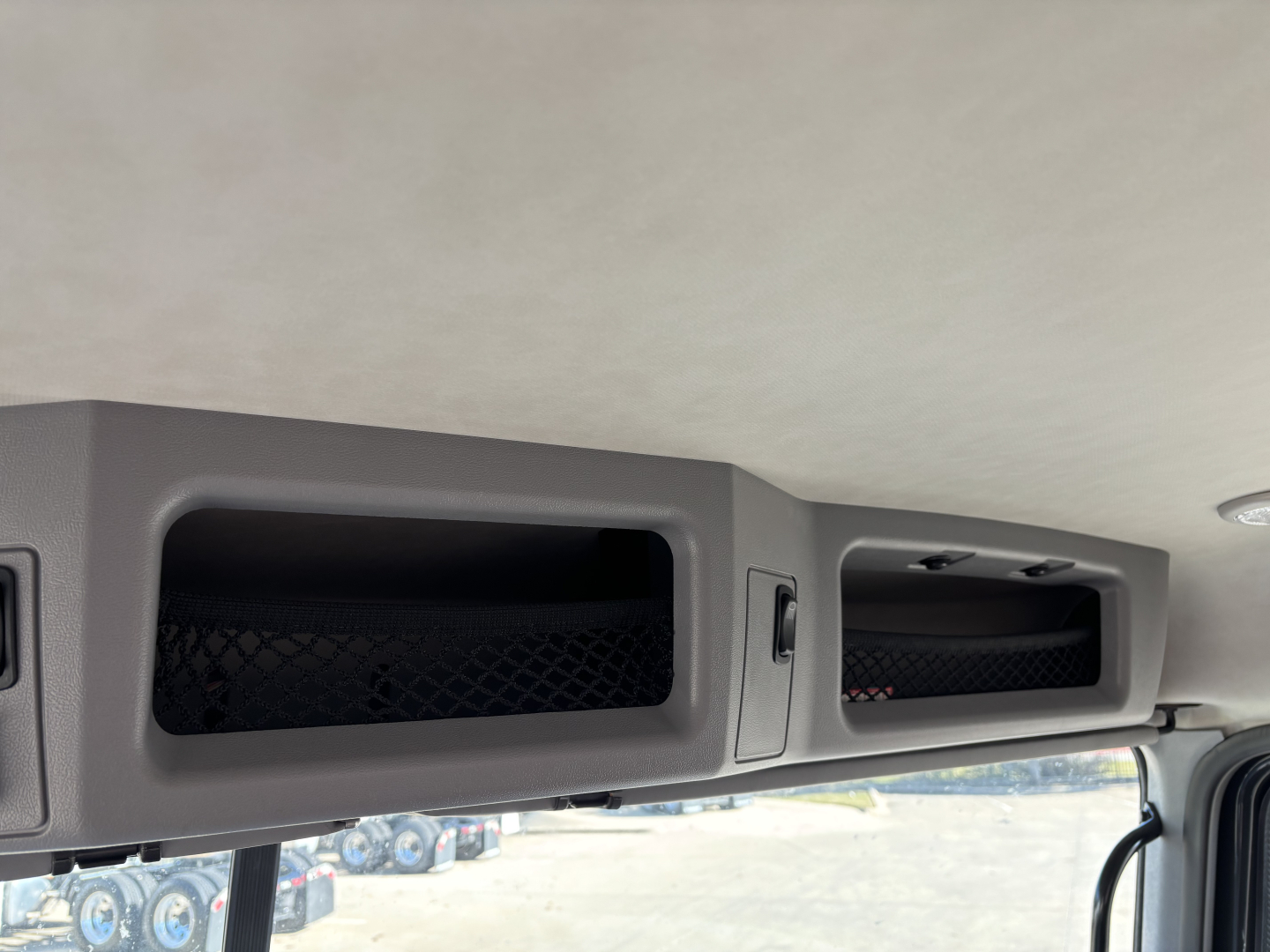 Cab and chassis interior overhead storage compartments with mesh panels and latches, interior roof panel visible.