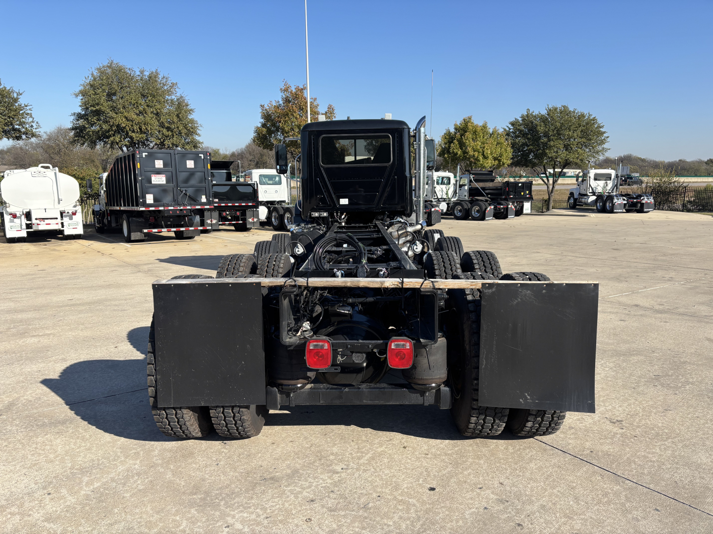 Mack GR64B cab and chassis rear view showing dual rear wheels and platform with fuel tanks or tool boxes mounted on sides.