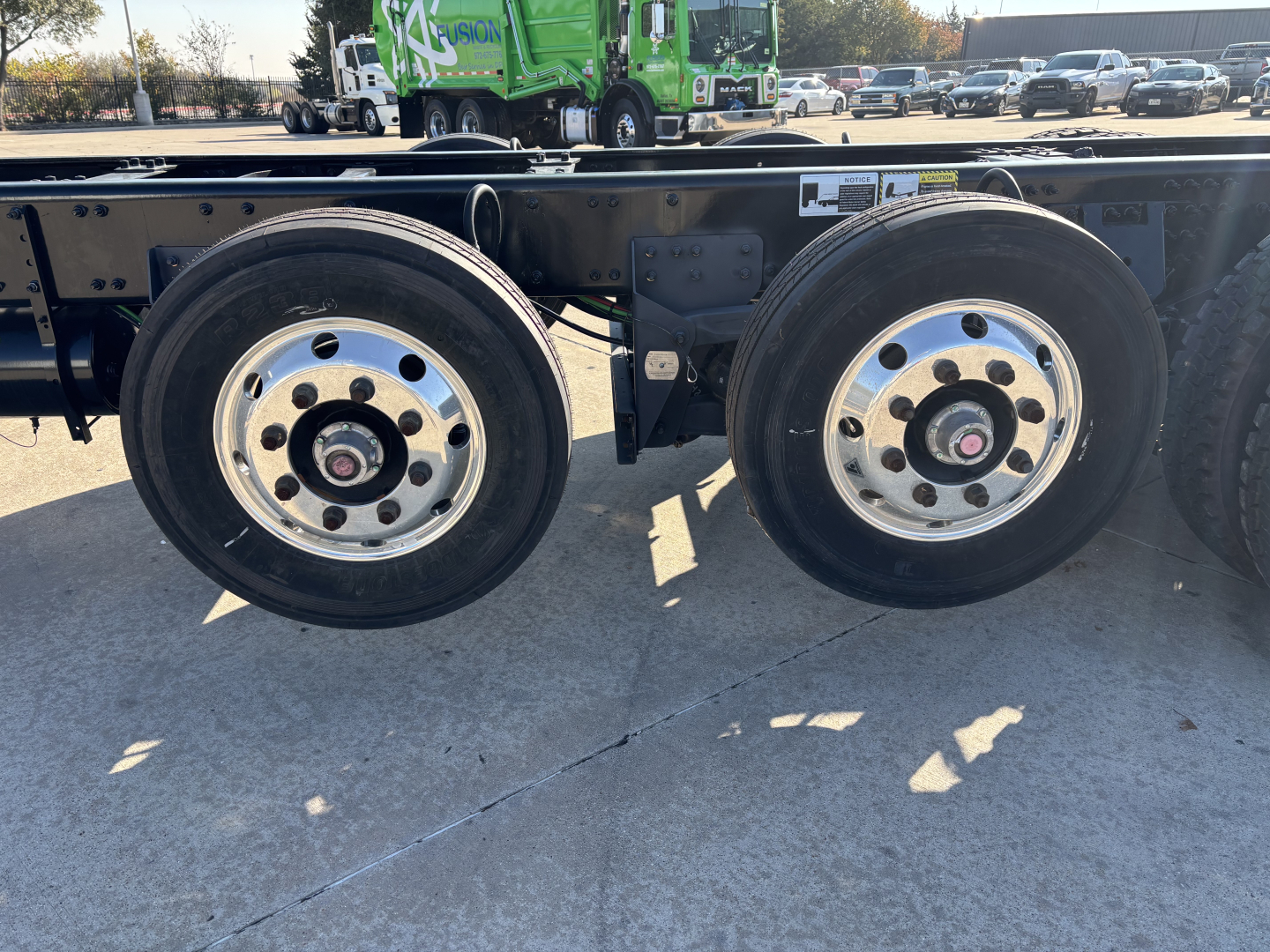 Dual rear wheels on a Mack GR64B chassis showing aluminum rims and black tire treads.