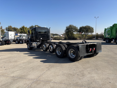 2025 Mack GR64B cab and chassis truck viewed from rear-left side on lot with black cab and multiple axles.