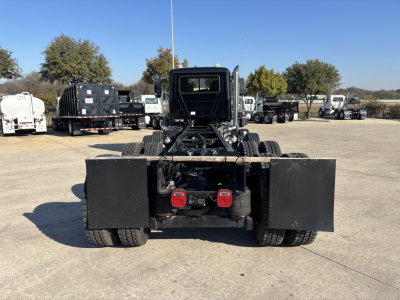 Mack GR64B cab and chassis rear view showing dual rear wheels and platform with fuel tanks or tool boxes mounted on sides.