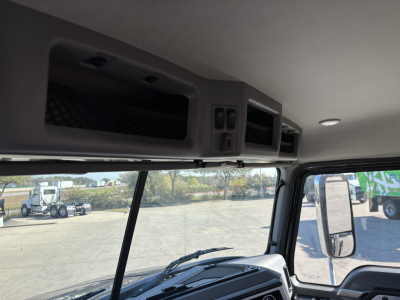 Cab interior upper dash area showing storage compartments and overhead controls in a 2025 Mack GR64B cab chassis.