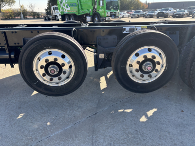 Dual rear wheels on a Mack GR64B chassis showing aluminum rims and black tire treads.