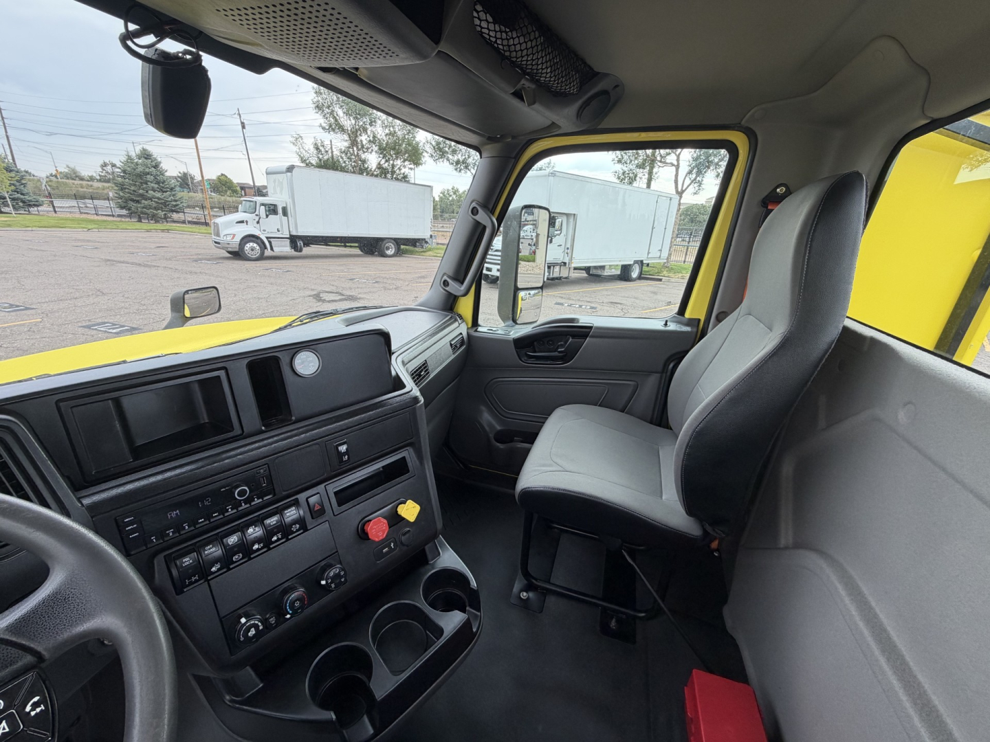Cab interior of a 2023 International LT625 truck showing steering wheel, dashboard, driver seat, and passenger seat from the left.