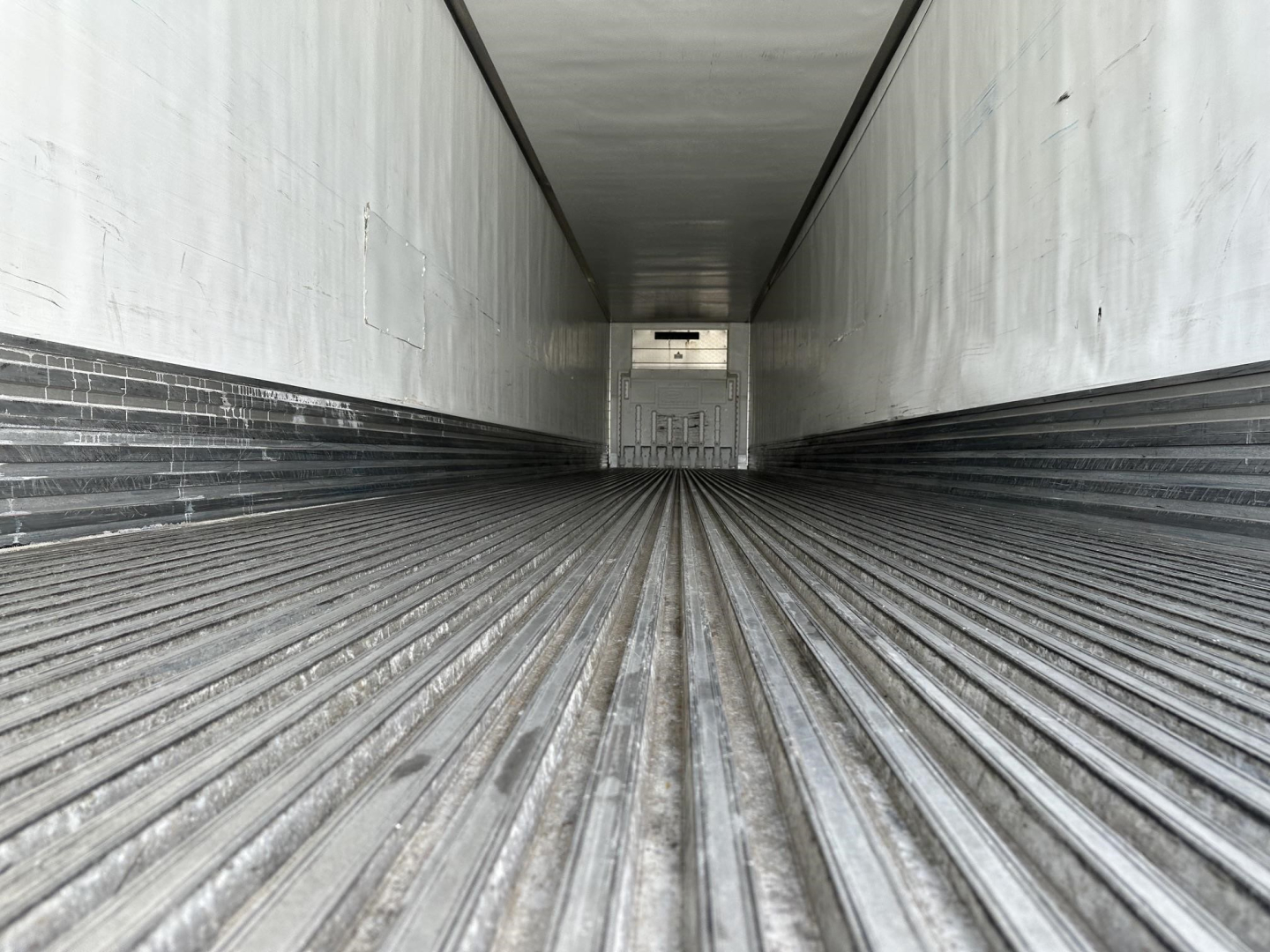 Trailer interior showing ribbed floor of a 2018 Utility 3000R reefer trailer with white walls and rear door.