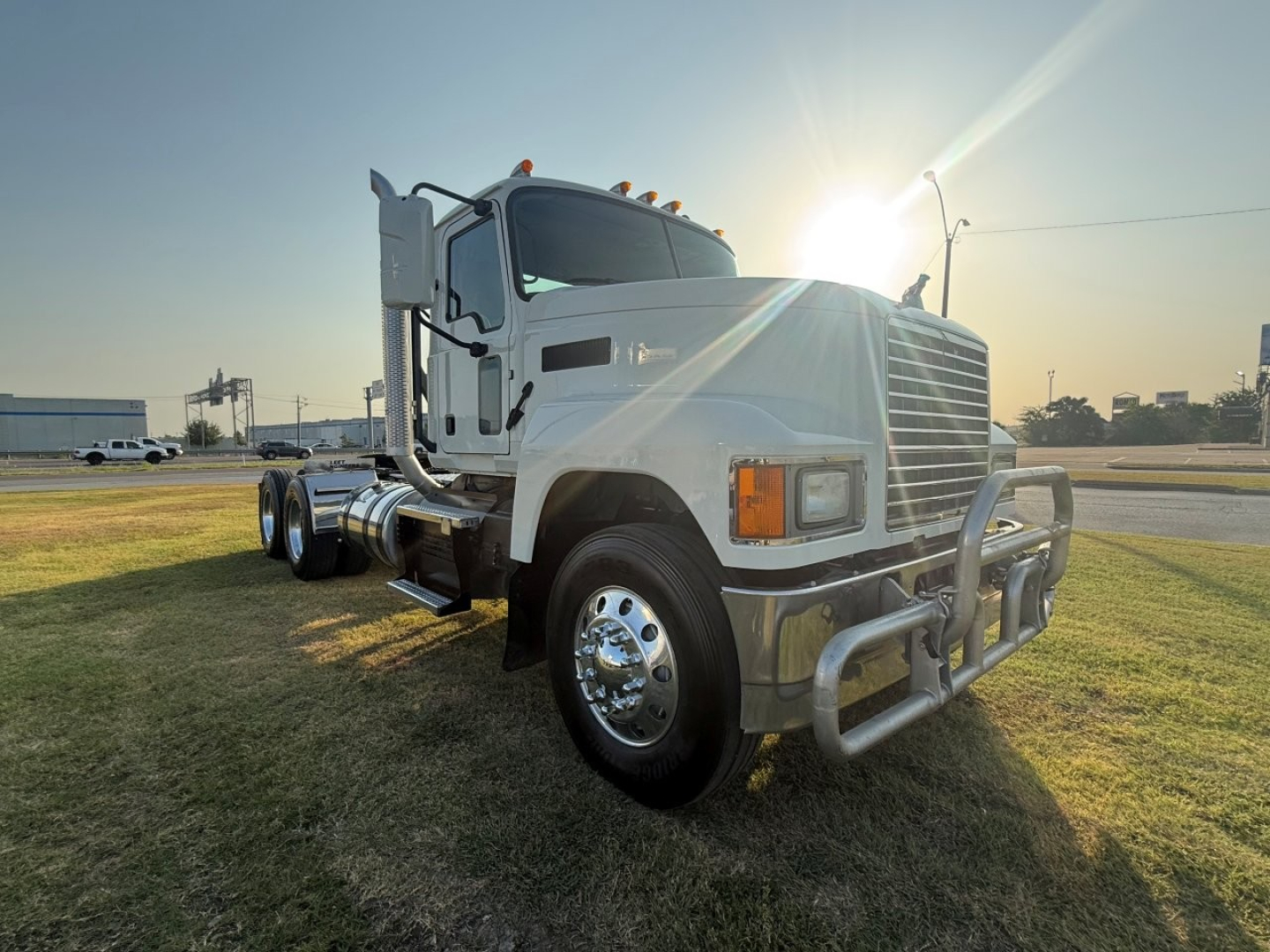 Truck cab and front view of a 2020 Mack PI64T conventional daycab with chrome bumper and grille, sun glare