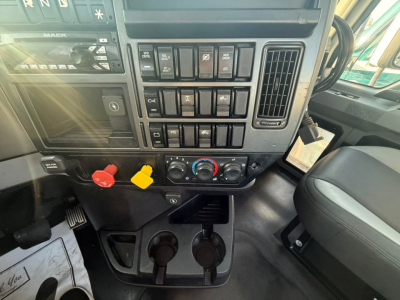 Dashboard of a 2020 Mack PI64T truck showing toggle switches, climate controls, and cup holders in center console.