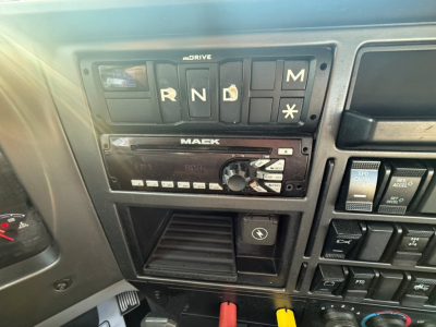 Dashboard of a 2020 Mack PI64T showing gear selector panel with R N D M, plus a Mack radio, control buttons, and a vent area.