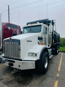 Kenworth T800 dump truck in white, front view showing large chrome grille, bumper, and side mirrors.