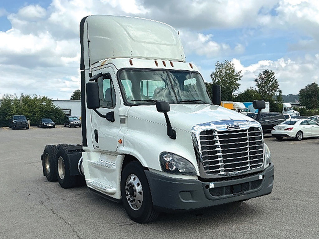 Truck cab in daytime view showing Freightliner Cascadia Evolution 2019 sleeper cab with chrome grille and white exterior.
