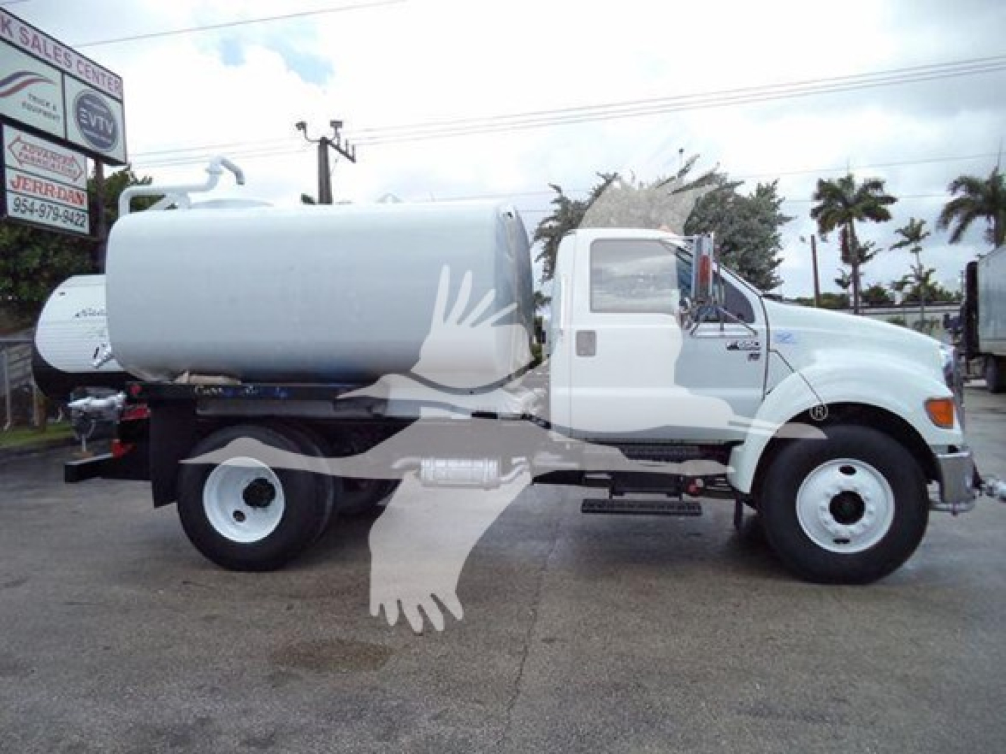 Truck side view of a 2015 Ford F650 SD with a large cylindrical tank mounted on the chassis, white cab, black fuel tank under, stock number T30599 visible at a dealership.