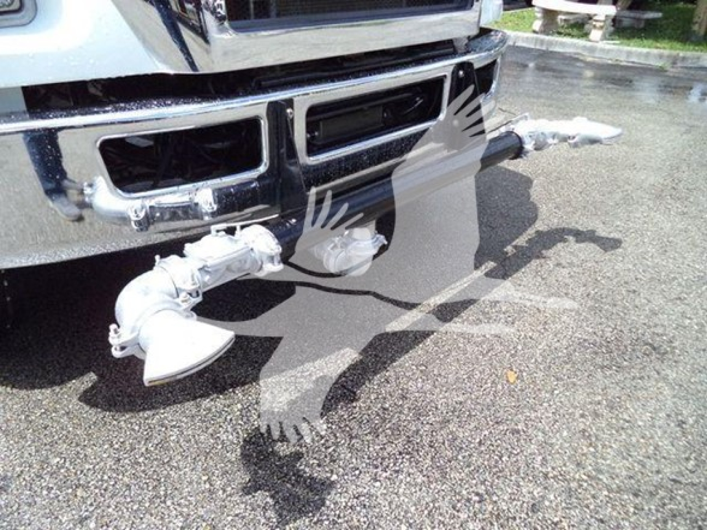 Front bumper area of a 2015 Ford F650 SD with a chrome grille and customized dual front bumper-mounted LED light bars; visible are stubs and piping from the truck’s front. 