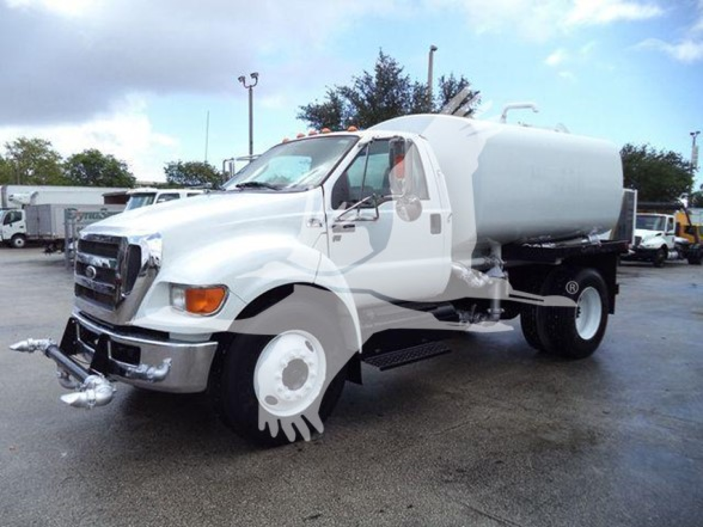 Ford F-650 truck with large cylindrical tank in white, front view showing bumper and front wheel assembly.